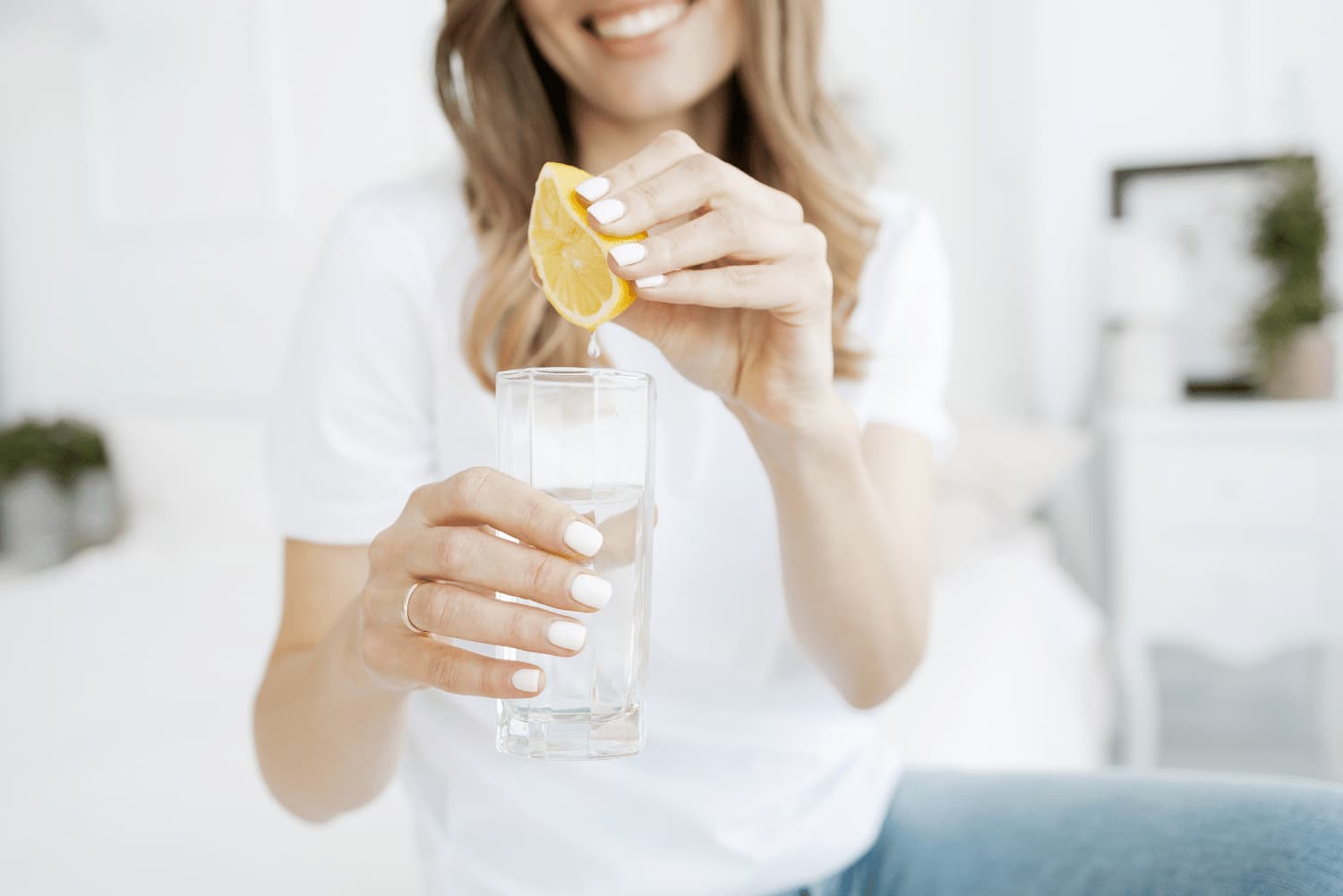 Ragazza spreme succo di limone in un bicchiere d'acqua